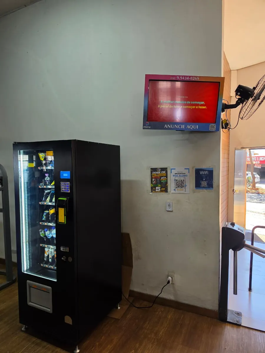 Sala de espera com TV na parede exibindo conteúdo da PratikMídia